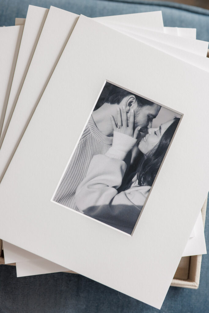 Close up of matted engagement photos with fine art paper and soft neutral tones
