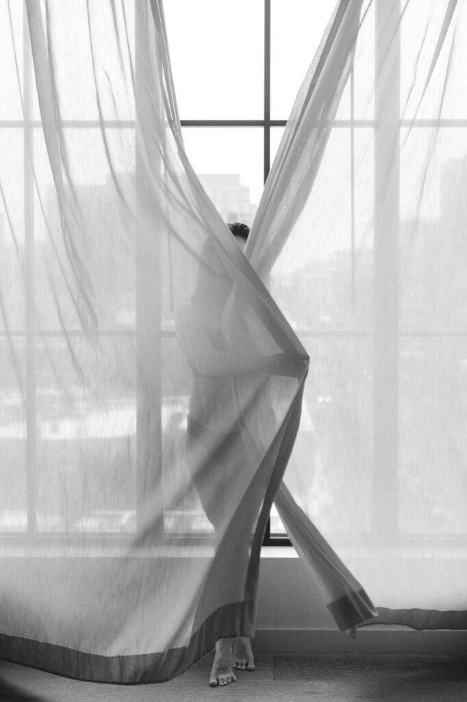 Sheer curtains blowing in soft natural light by window