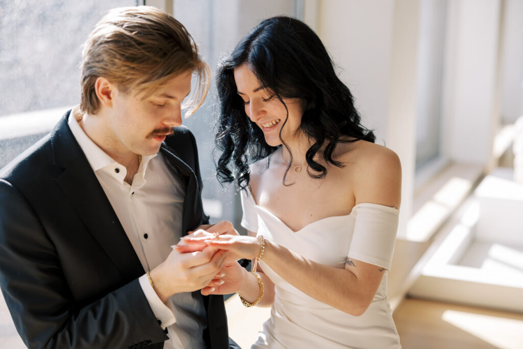 Engagement ring moment photo couple looking at ring in window light