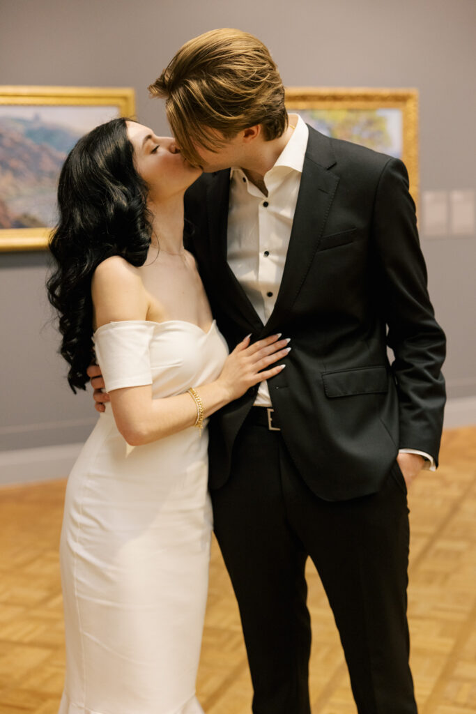 Romantic engagement photo inside museum gallery with couple embracing