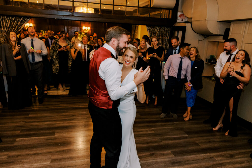 Bride And Groom Dancing Surrounded By Guests