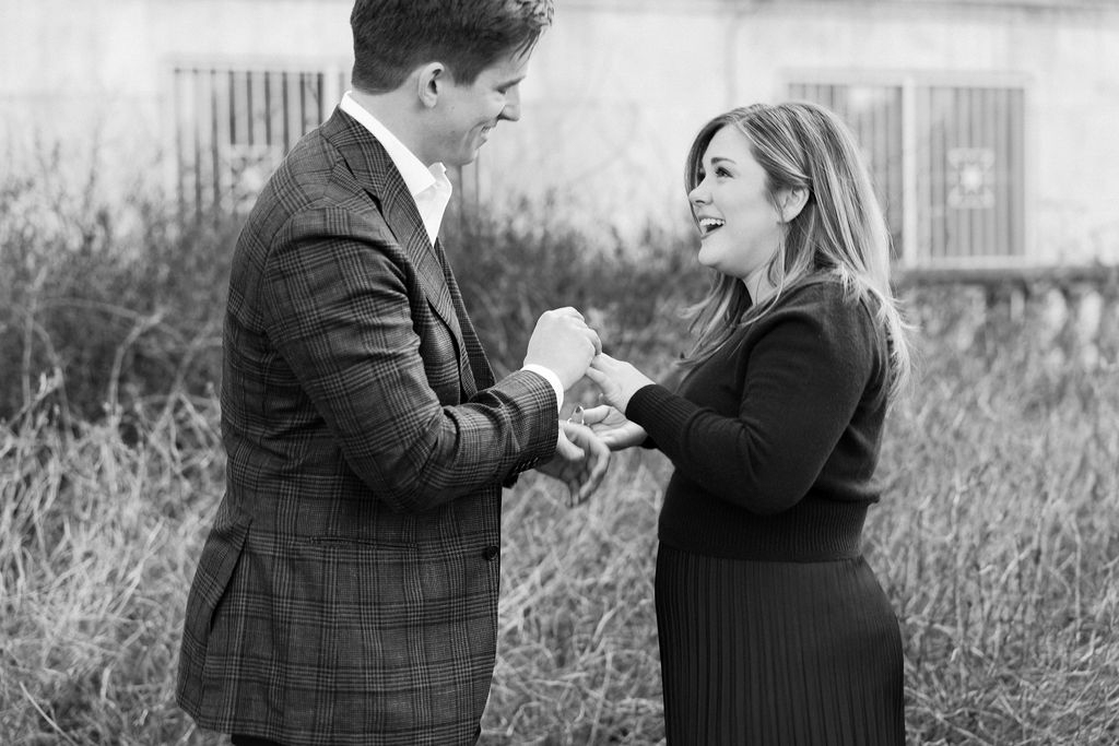Black and white photo of couple exchanging vows outdoors