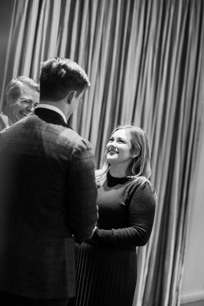 Bride smiling during ceremony with guests in background