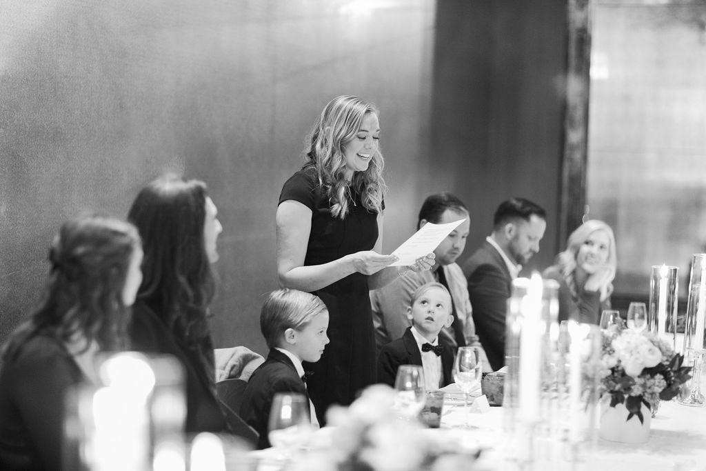 Guests seated at candlelit dinner table during ceremony