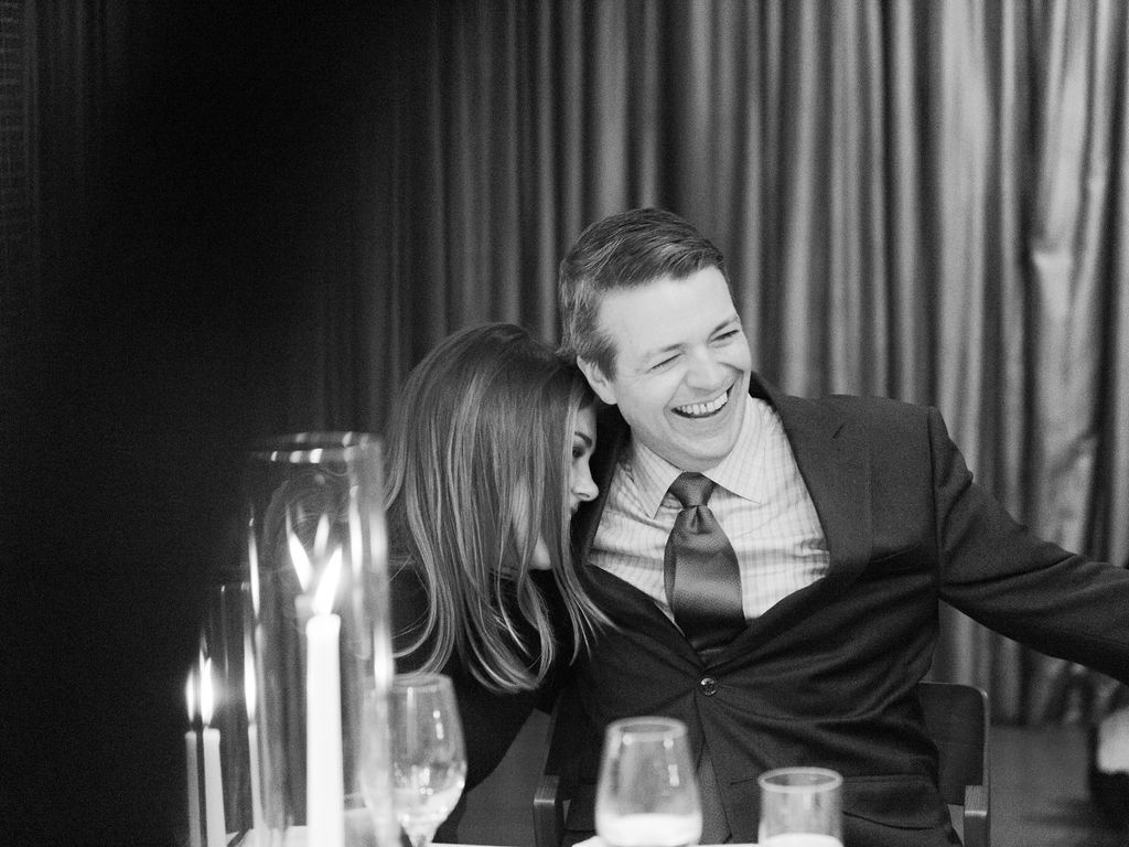 Guests talking and laughing at candlelit dinner table