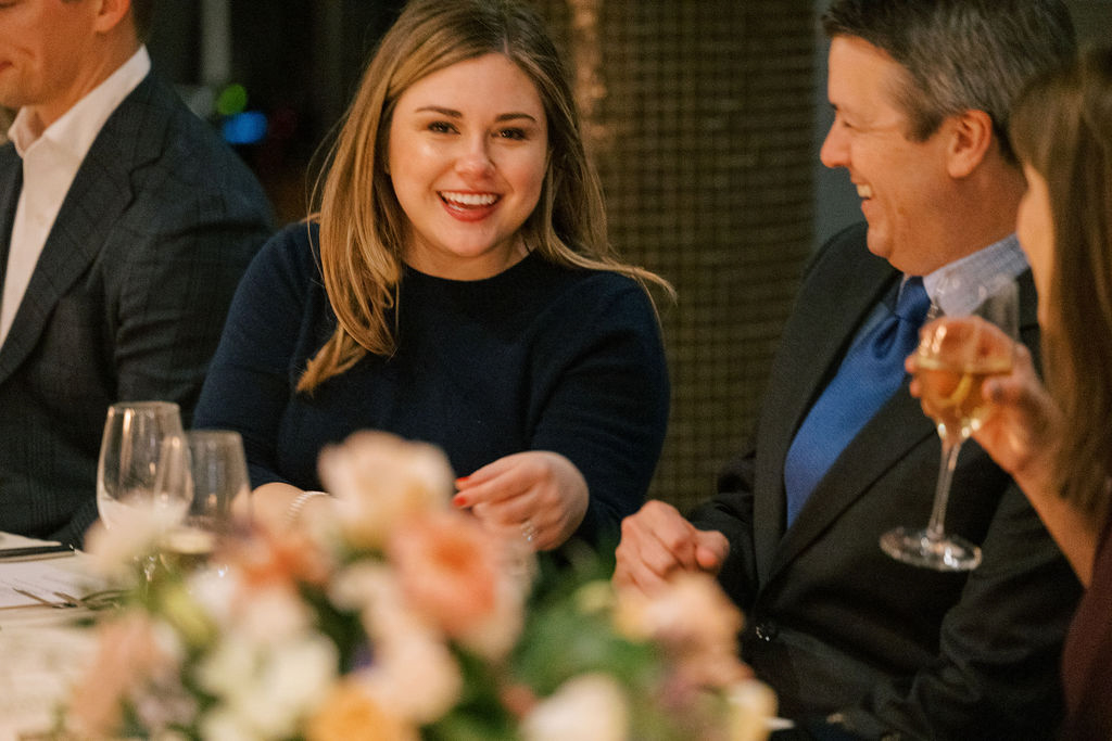 Bride smiling at dinner table with guests