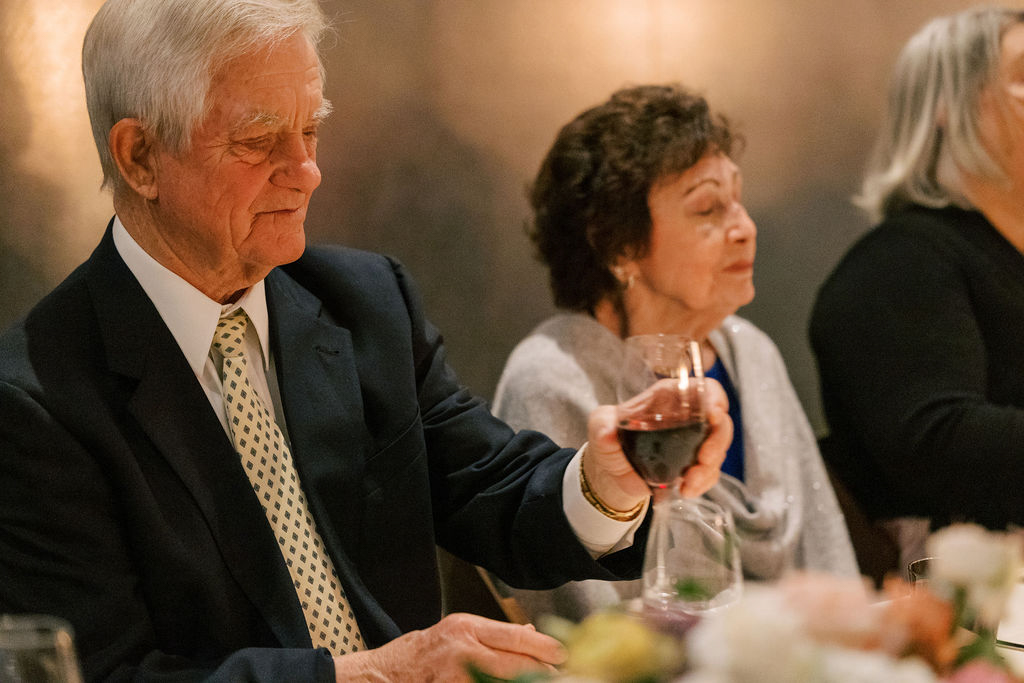 Guests talking and laughing at candlelit dinner table