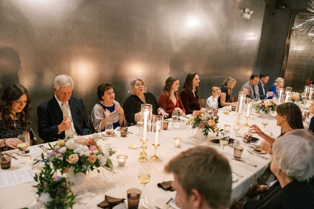 Guests talking and laughing at candlelit dinner table
