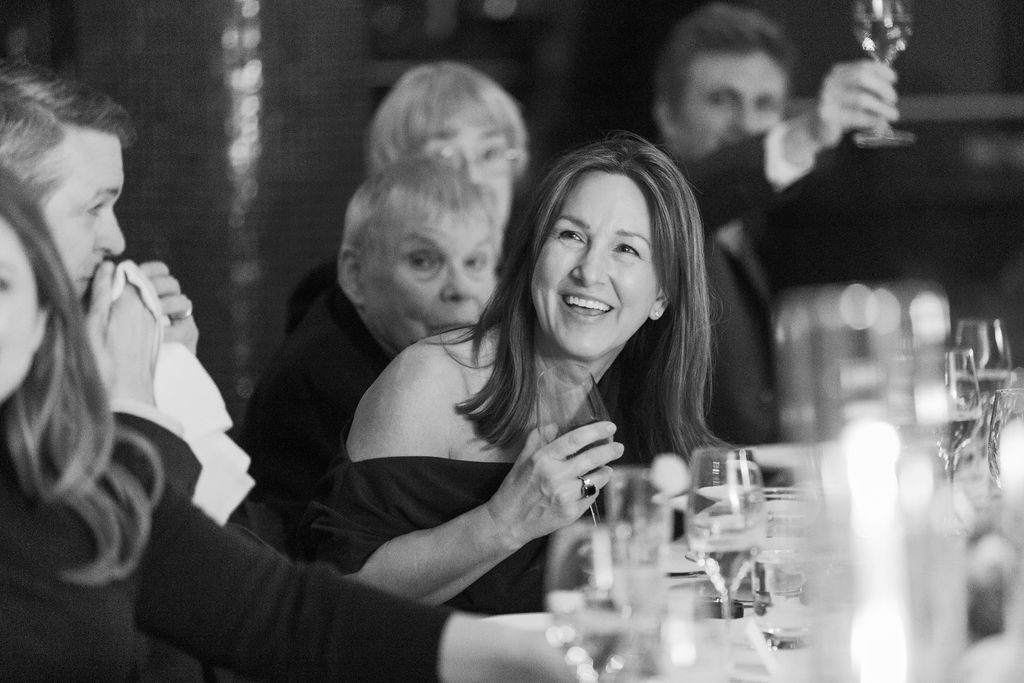 Guests reacting and smiling during dinner speeches