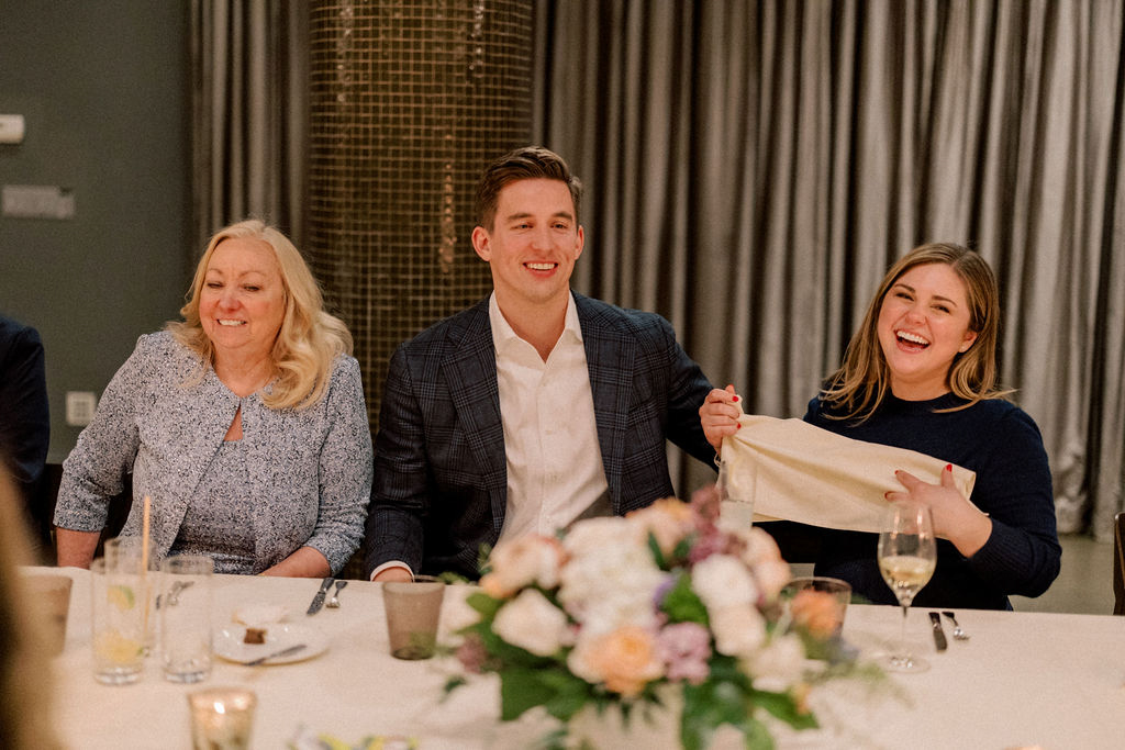 Guests talking and laughing at candlelit dinner table