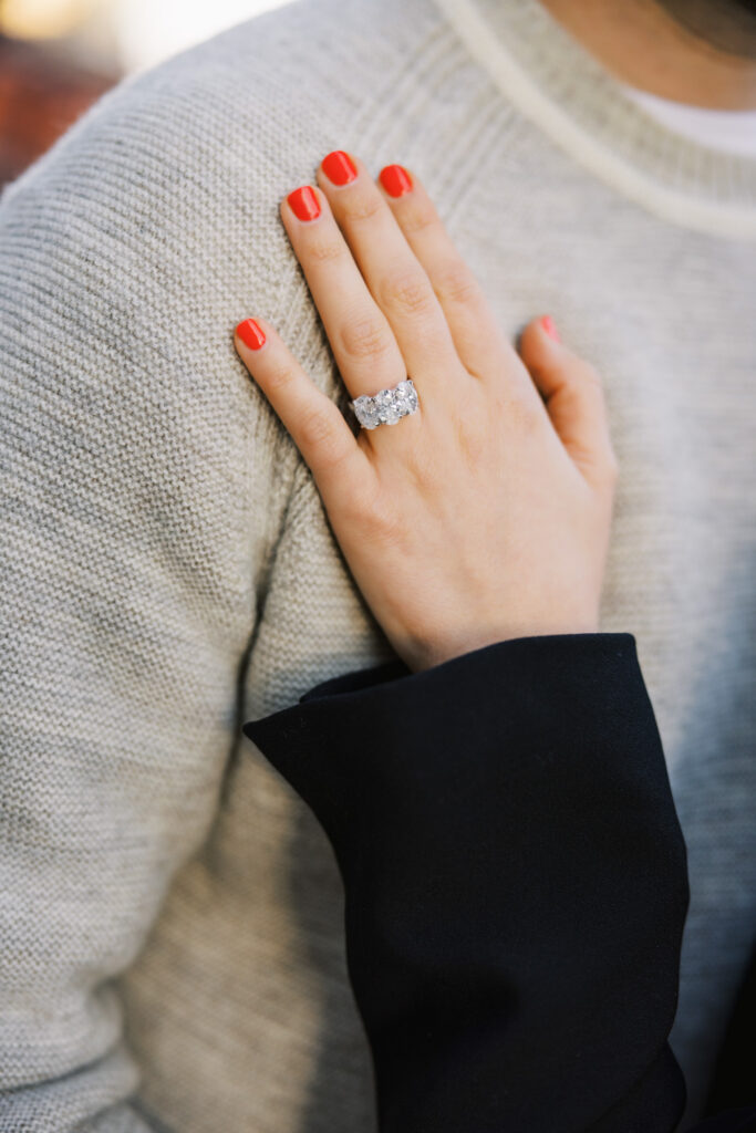 Engagement Ring Close Up On Hand With Red Nails